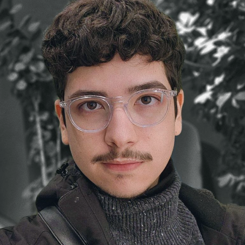 Pedro Ventura, smiling, wearing clear-frame glasses.